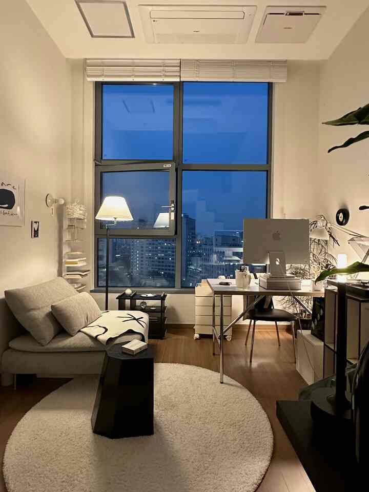 A compact living room-style home office featuring white and brown tones with modern natural furniture layout