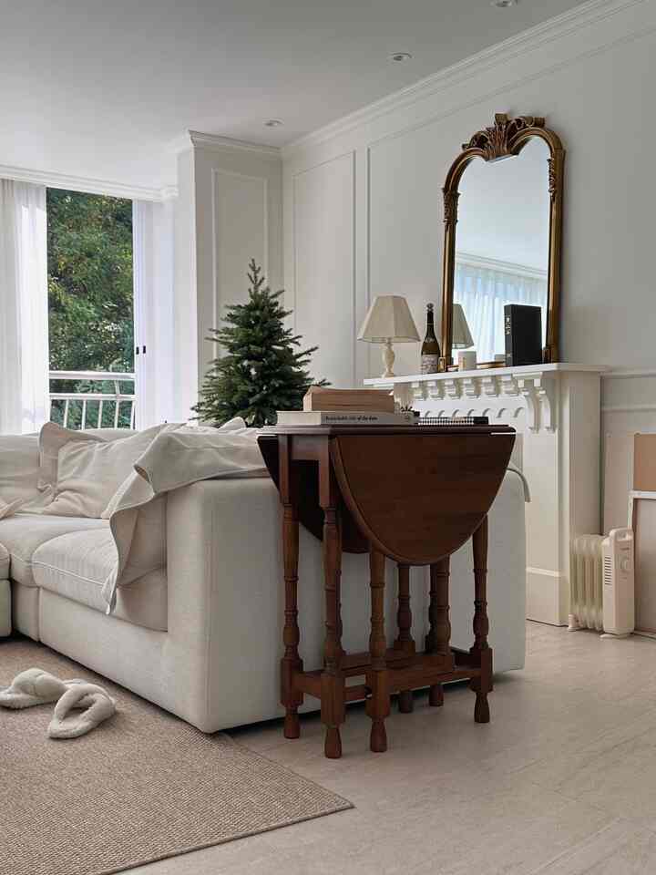 Natural tone living room featuring beige sofa, wooden table, and gold decorative mirror with a cozy atmosphere