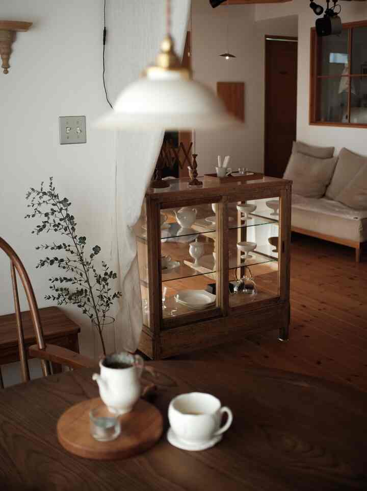 温かな木目調とナチュラルな色調が調和するリビングとダイニング、ソファとダイニングテーブルが配置された雰囲気のあるインテリア