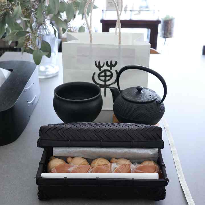 Monotone modern Japanese interior featuring a tea set and traditional sweets arranged in a cozy home cafe setting