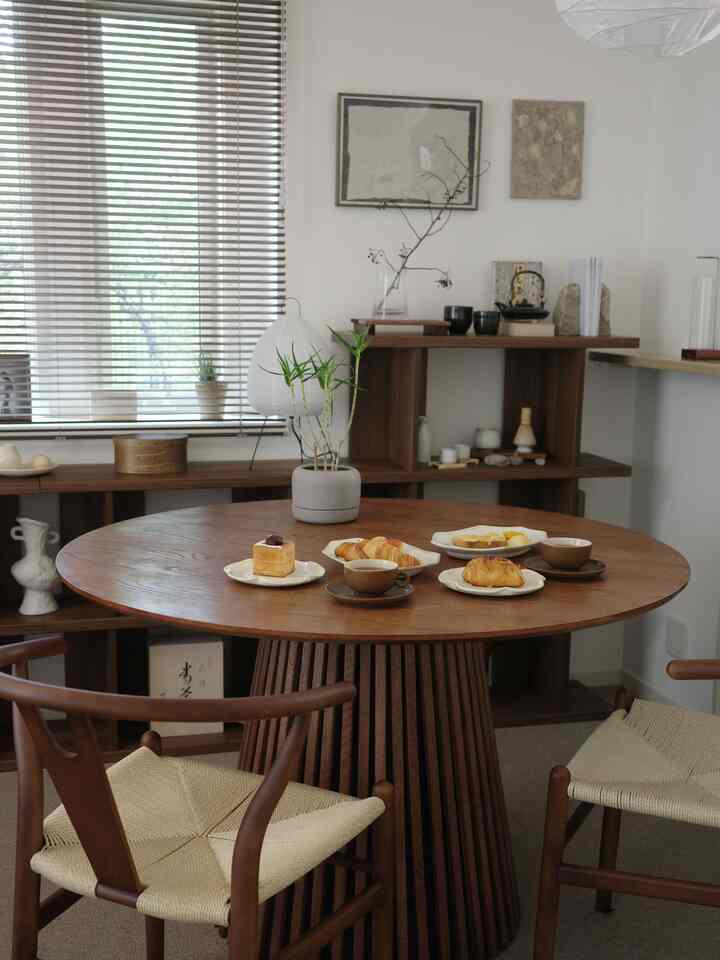 Cozy living room dining area with warm wood tones and natural modern style, featuring a home cafe setup on the round table