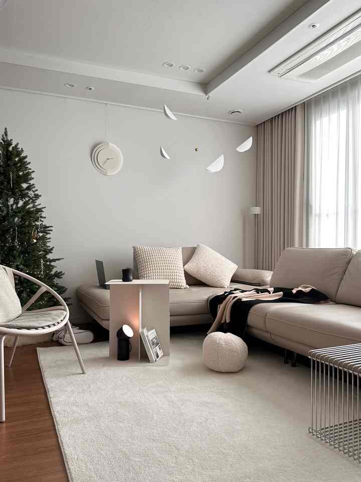 A natural modern living room in warm beige and ivory tones featuring a Layer Fave steel magazine table and light beige sofas