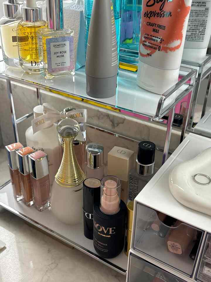 ホワイトとシルバー調の化粧台上に配置された2段モジュールの化粧品整理棚、整理された高級感のある空間