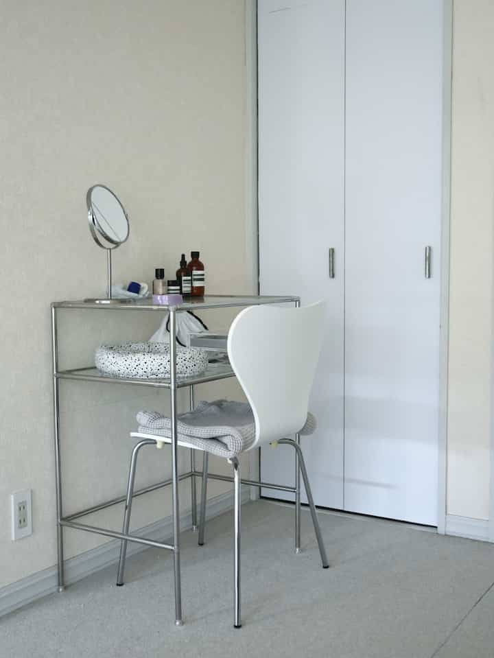 Simple living room in white and silver tones featuring a modular stainless steel dresser and Series 7 chair with minimal design