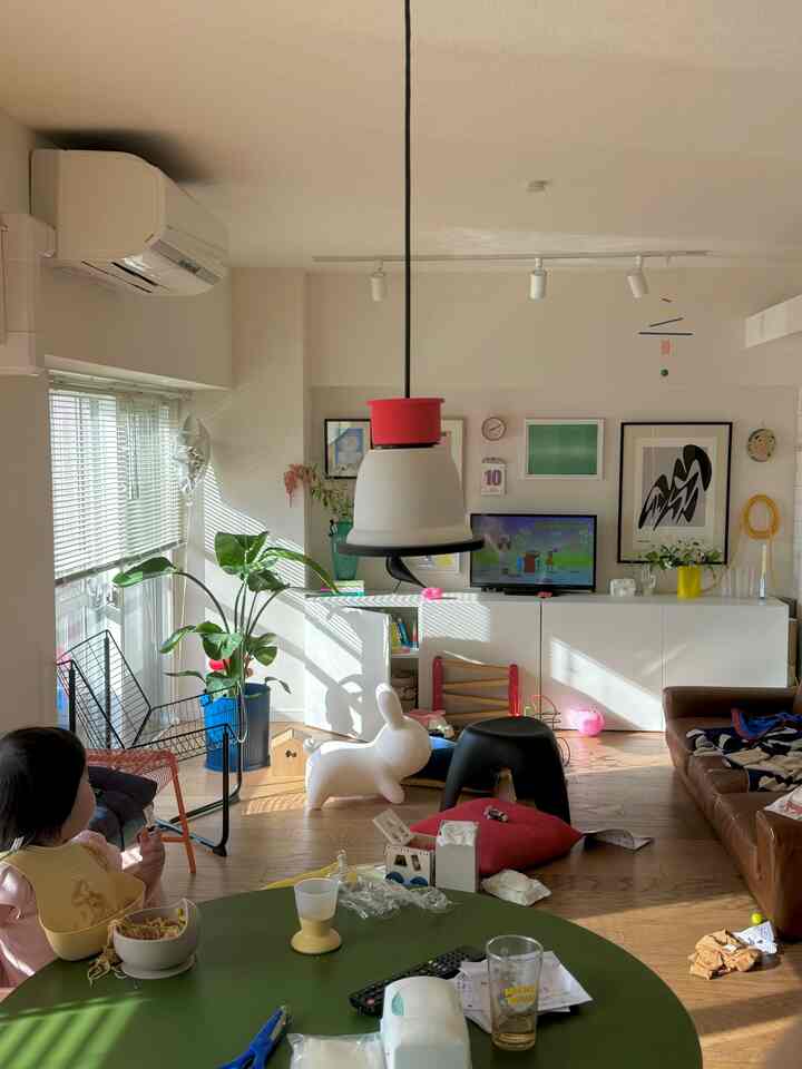 明るいホワイトとブラウンの色調のリビング、子供向けの家具とおもちゃが配置された雰囲気のある空間