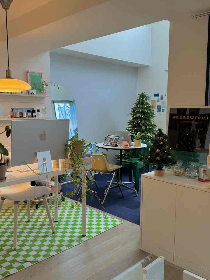 白い壁と天井のナチュラルなホームオフィス、クリスマスツリーとイルミネーションが配置された雰囲気あるインテリア