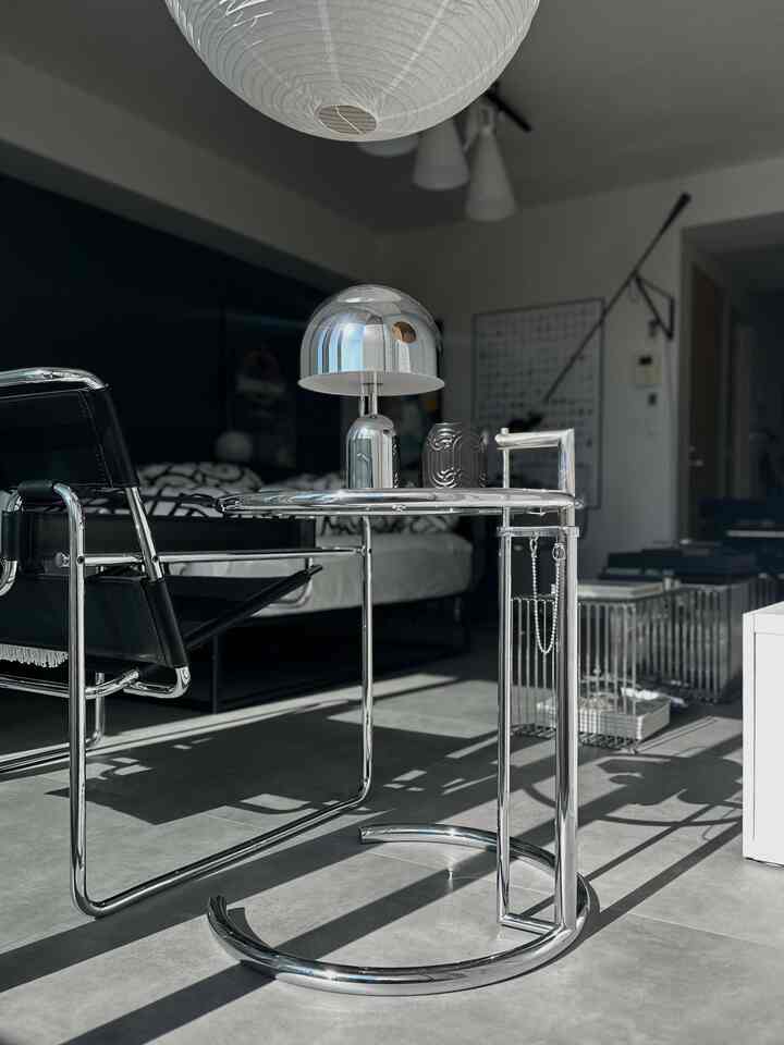 Modern living room in black and silver tones featuring chrome side table and Wassily armchair in a sleek setting