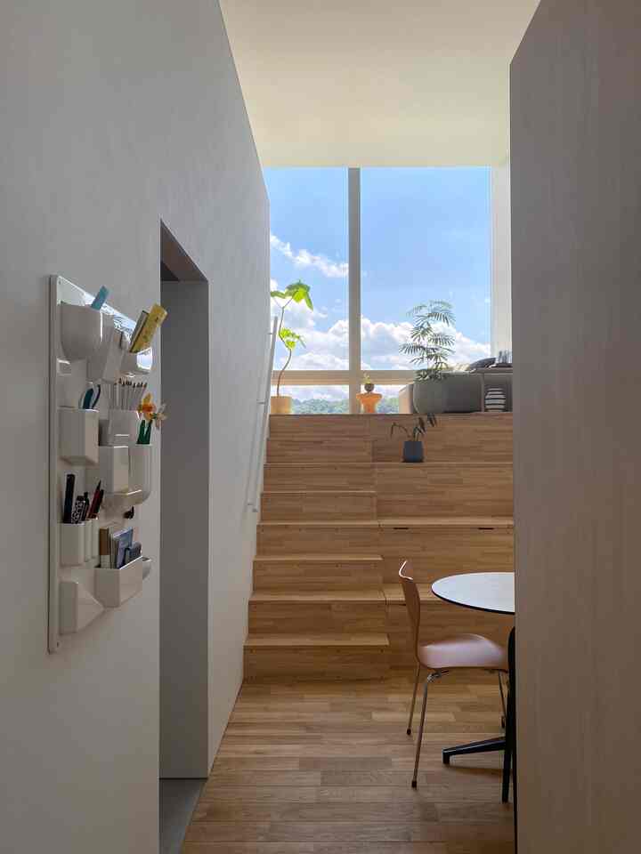 ライトブラウンの木目調が印象的なスカンジナビアスタイルの玄関、広い窓と自然光が豊かな雰囲気のインテリア