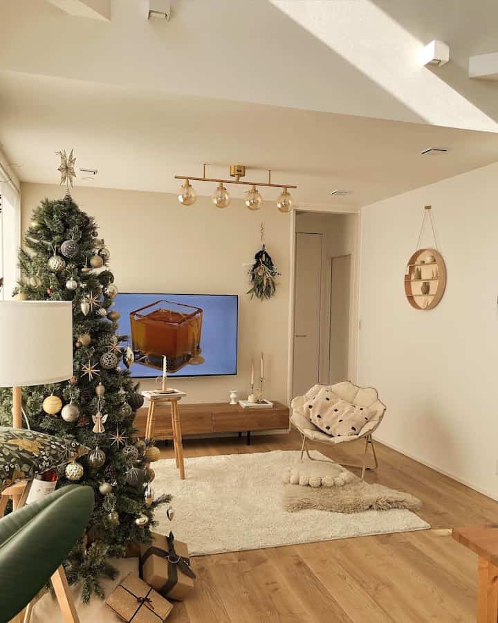 ナチュラルな木目調と白を基調としたリビング、クリスマスツリーとラグが温かみのある雰囲気を演出するインテリア