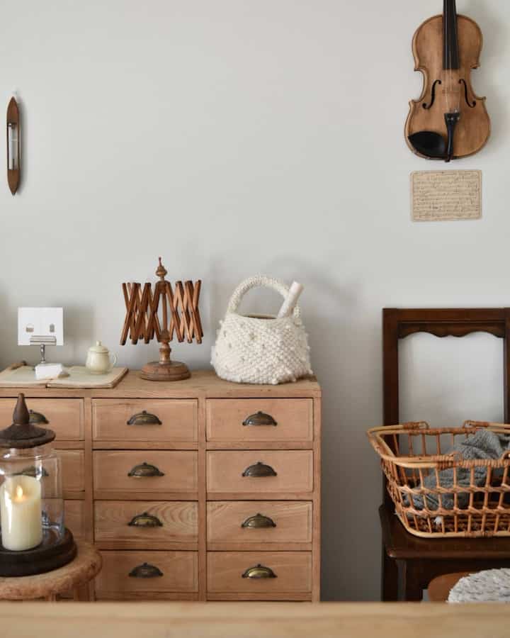 Natural wood tone space featuring French country style elements, a violin on the wall, and candle decor in a cozy setting