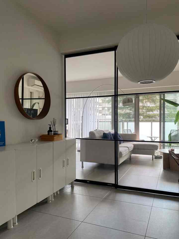 白を基調とした透明なガラス仕切りが特徴的なミッドセンチュリーモダンのリビング兼ワークスペースのインテリア