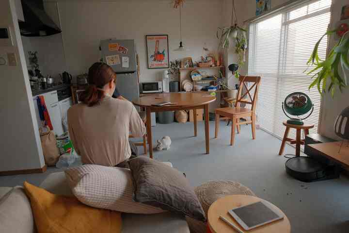 Natural-toned dining room featuring wooden round dining table and chairs with a small rabbit on the floor in a cozy setting