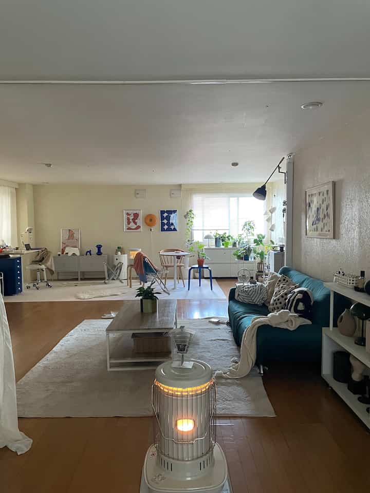 White and wood tone dominated 1LDK studio living room, cozy Nordic Mid-Century Modern interior with dog-friendly space