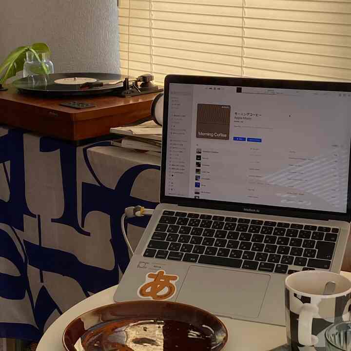 ベージュのブラインドとヴィンテージの木製ターンテーブルが配置された、ナチュラルカラーのワンルーム、雰囲気のあるおうちカフェ空間