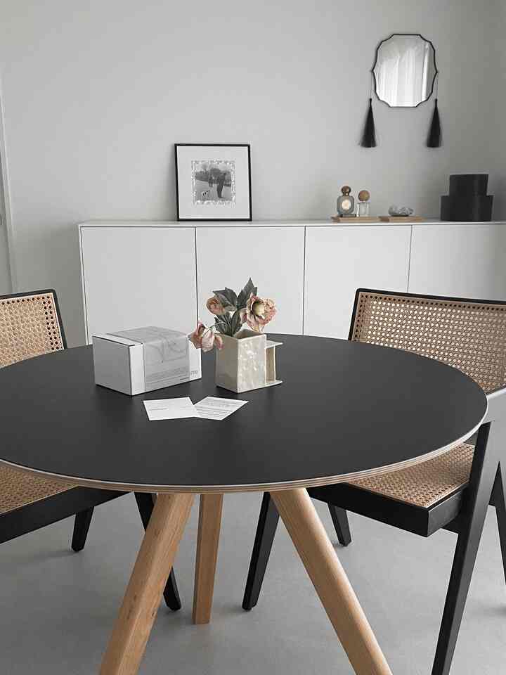 ホワイトとブラック、ナチュラルトーンのダイニングルーム、ラタンチェアと丸テーブルがモダンな雰囲気のインテリア