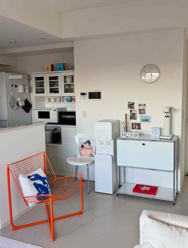 ホワイト調のリビング空間、キッチンコーナーとミニマルな家具が配置されたシンプルモダンな印象のインテリア