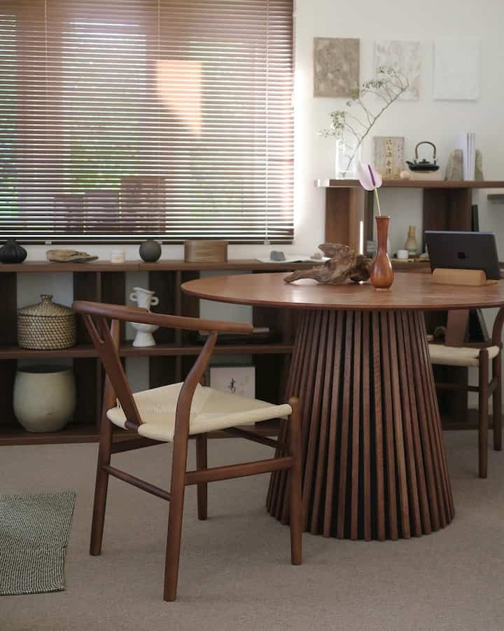 ナチュラルな木目調とブラウン色が調和するダイニング、丸いダイニングテーブルと椅子が配置された雰囲気のある空間