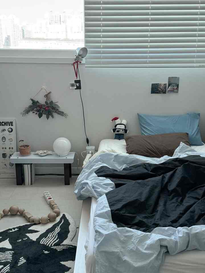 白と青のトーンの寝室、シンプルな家具と快適な寝具が配置された落ち着いた雰囲気のインテリア