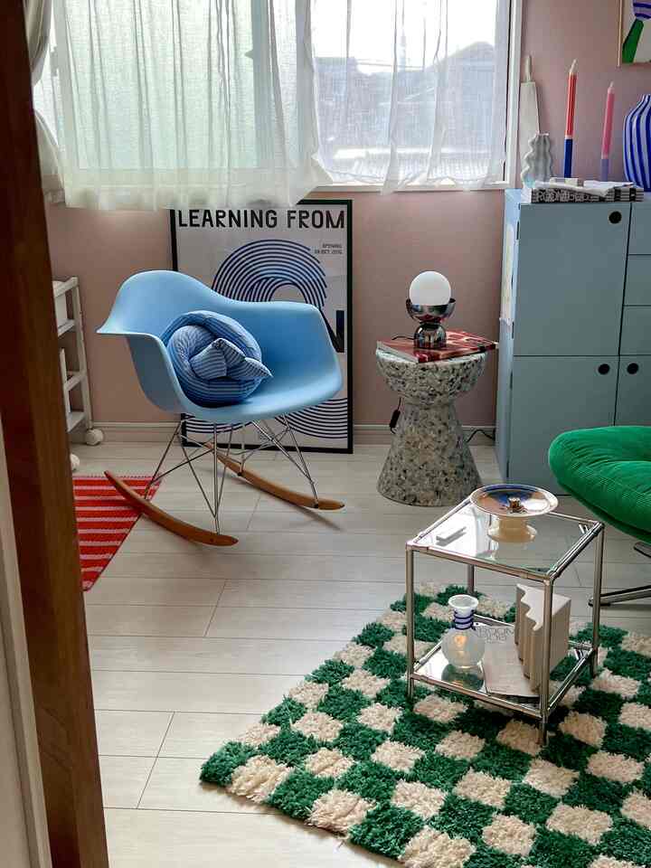 Pastel blue and green toned living room featuring a mid-century modern chair and side table creating a simple, cozy atmosphere