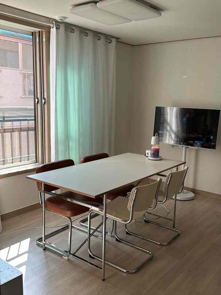 ホワイトと木目調が調和するダイニングルーム、シンプルなテーブルと椅子が配置されたモダンな空間