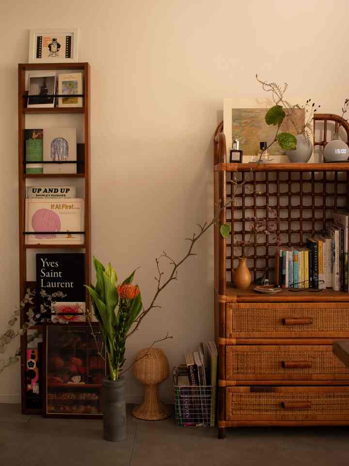 Beige and rattan toned studio study space featuring art books and vases with flowers, creating a warm, natural atmosphere