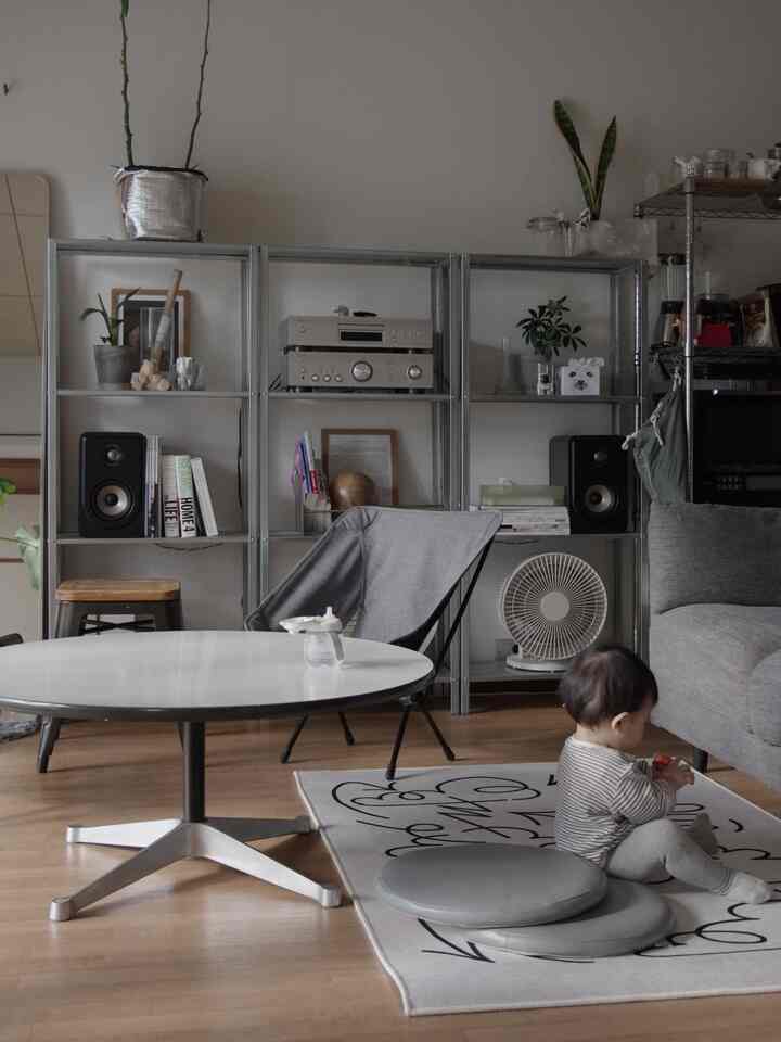 ベージュとナチュラルカラーのリビング、赤ちゃんとラグ、モダン家具が配置された居心地の良い空間