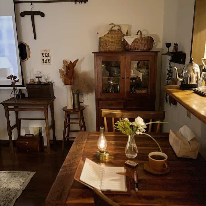 Warm brown-toned dining room featuring wooden furniture and coffee accessories with a cozy home cafe atmosphere