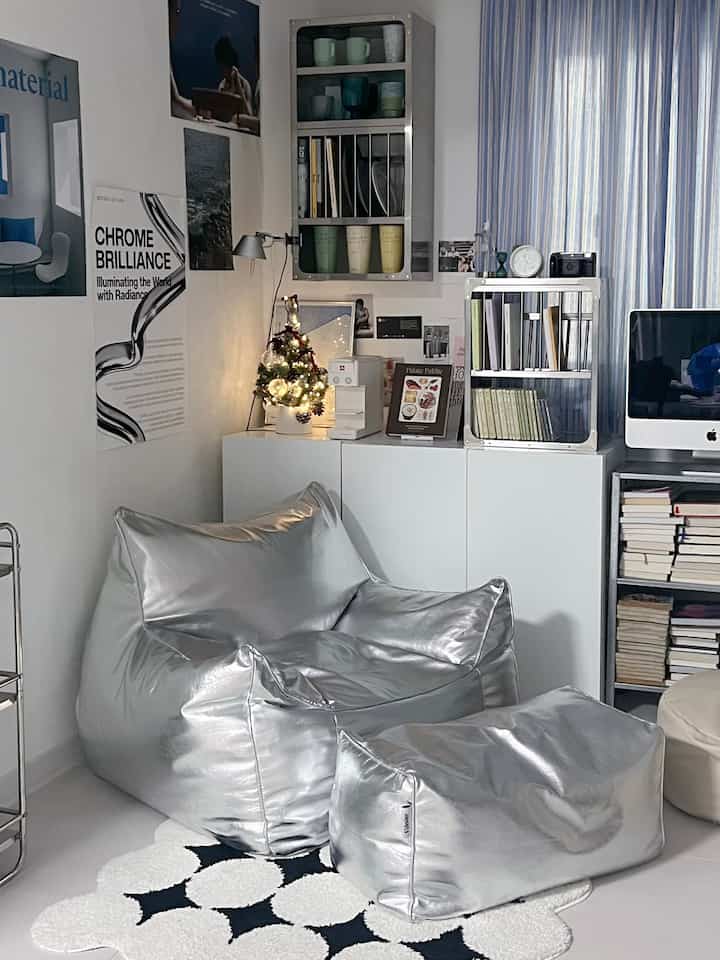 白とシルバーの色調のリビング、ビーンバッグソファと本棚が配置された雰囲気のある空間