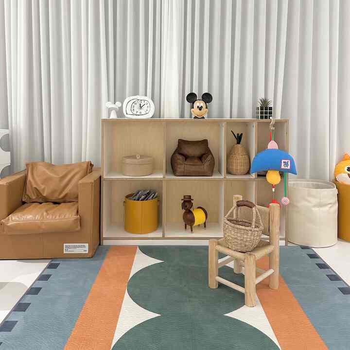 ベージュとブラウンの色調の子供用遊び部屋、かわいらしいおもちゃと収納が配置されたナチュラルな雰囲気のインテリア