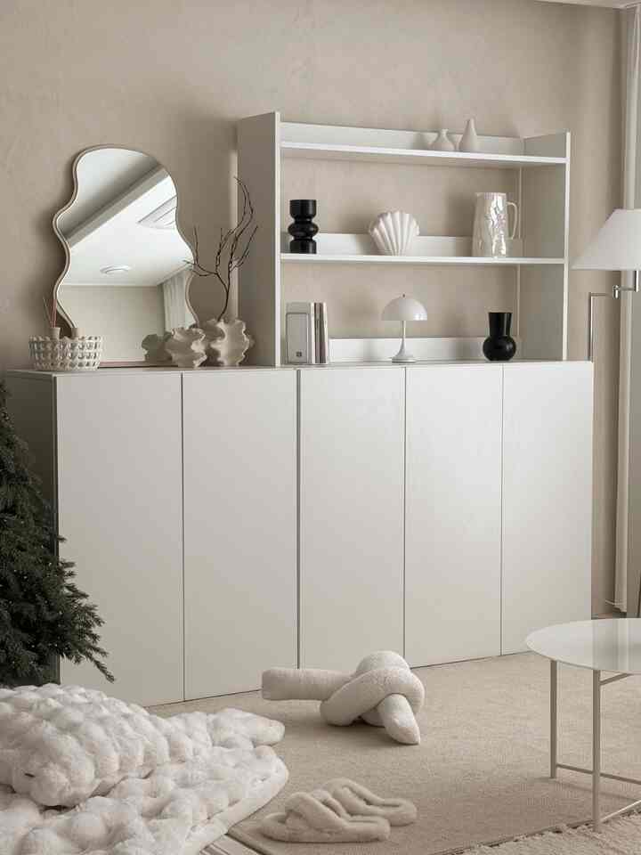 White and natural toned living room with simple modern storage cabinet and decorative items in a neat arrangement