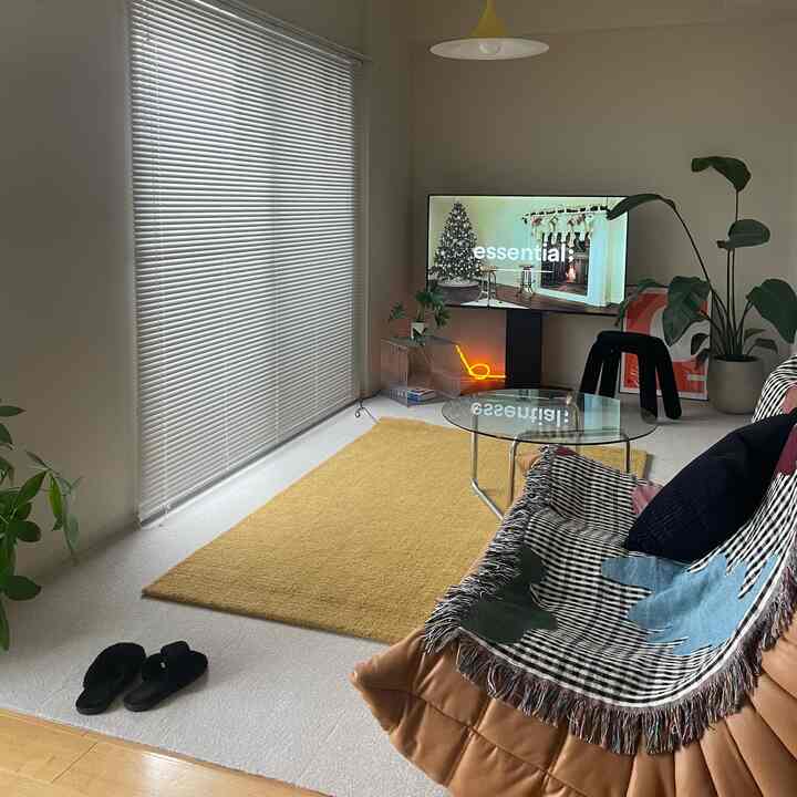 暖かい黄色と茶色のトーンのリビング、黄色いカーペットと茶色のソファが配置されたミニマルで自然な雰囲気のあるインテリア