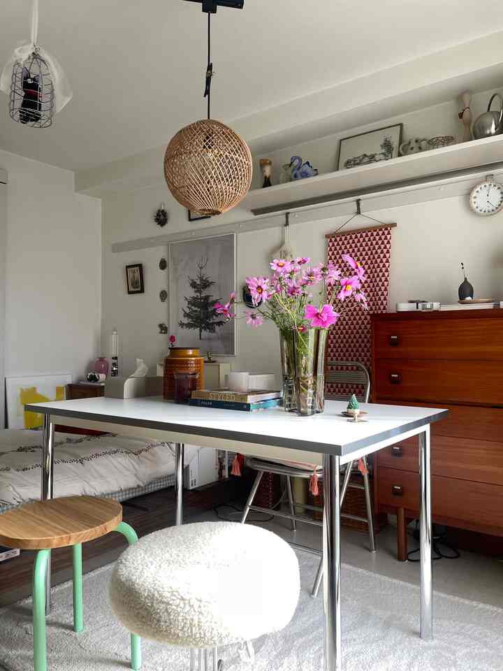 ホワイトとクロームのトーンの一人暮らしリビング、中央にデスクとスツールが配置されたモダンな雰囲気のあるインテリア