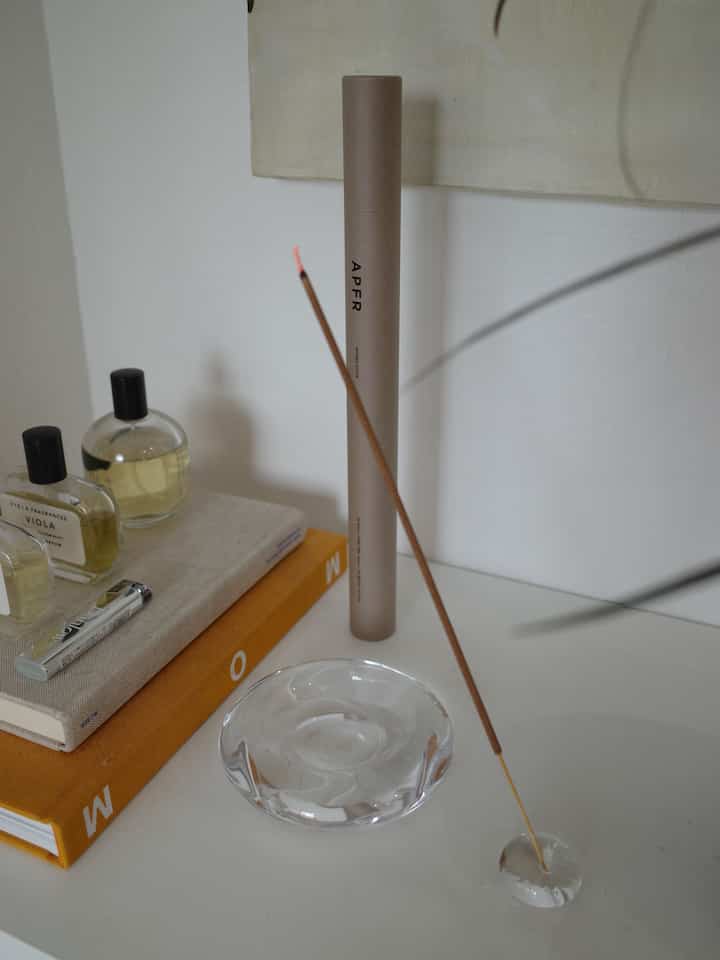 White and beige toned bedroom space featuring incense sticks and diffusers with a calm atmosphere