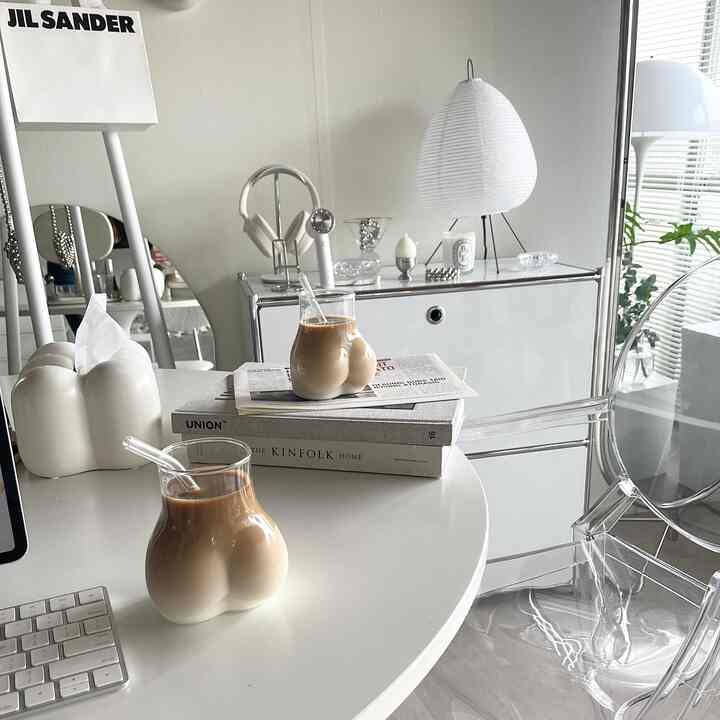 White and transparent toned home office featuring unique curved glass cups and minimalist furniture with a modern vibe