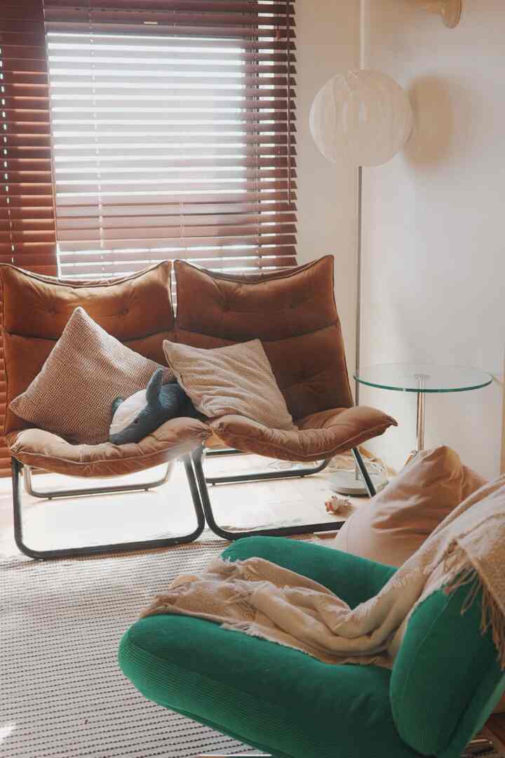 Natural toned living room featuring brown armchairs and a green sofa with a cozy atmosphere