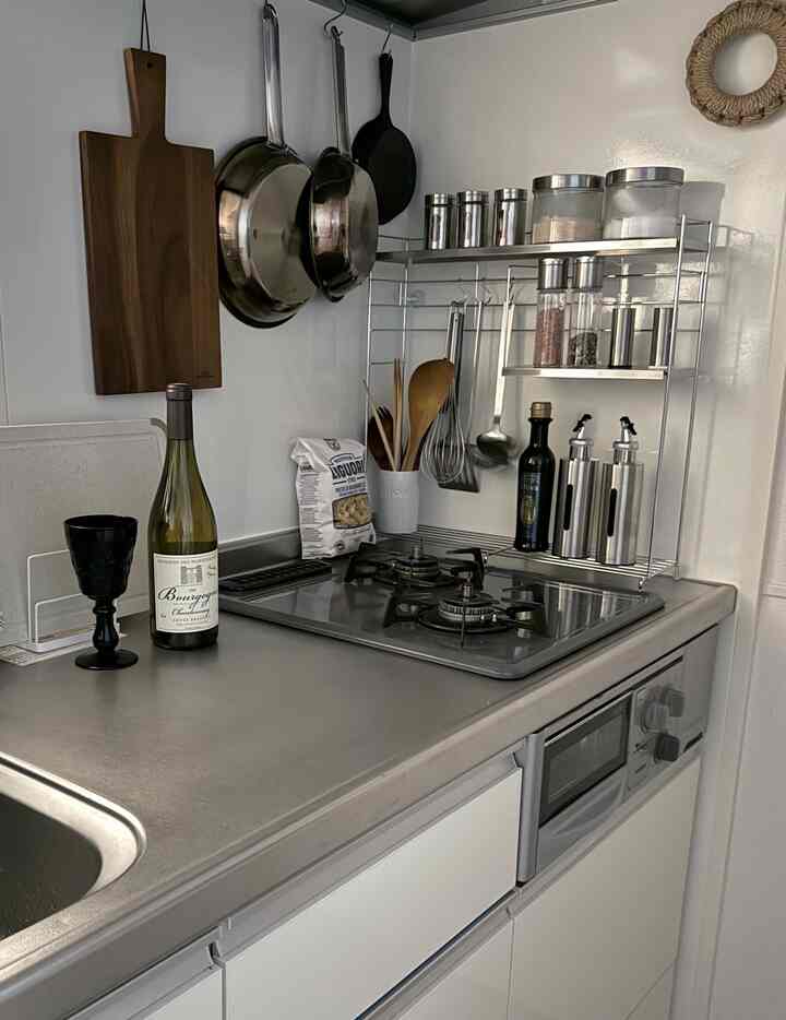 ステンレス調理台と白いキャビネットが配置された清潔感のあるキッチンの雰囲気のあるインテリア