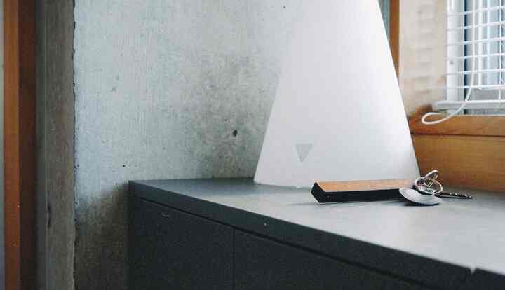 白と黒の玄関空間、シンプルなシューズラックとメイデイランプが配置されたミニマルなインテリア