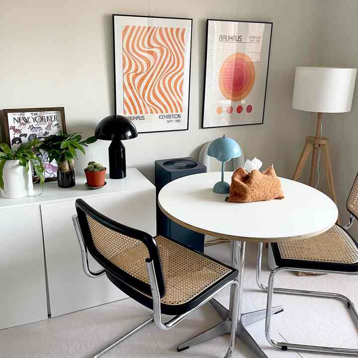 白い背景とミッドセンチュリーモダンの家具が配置された二人用のダイニング空間