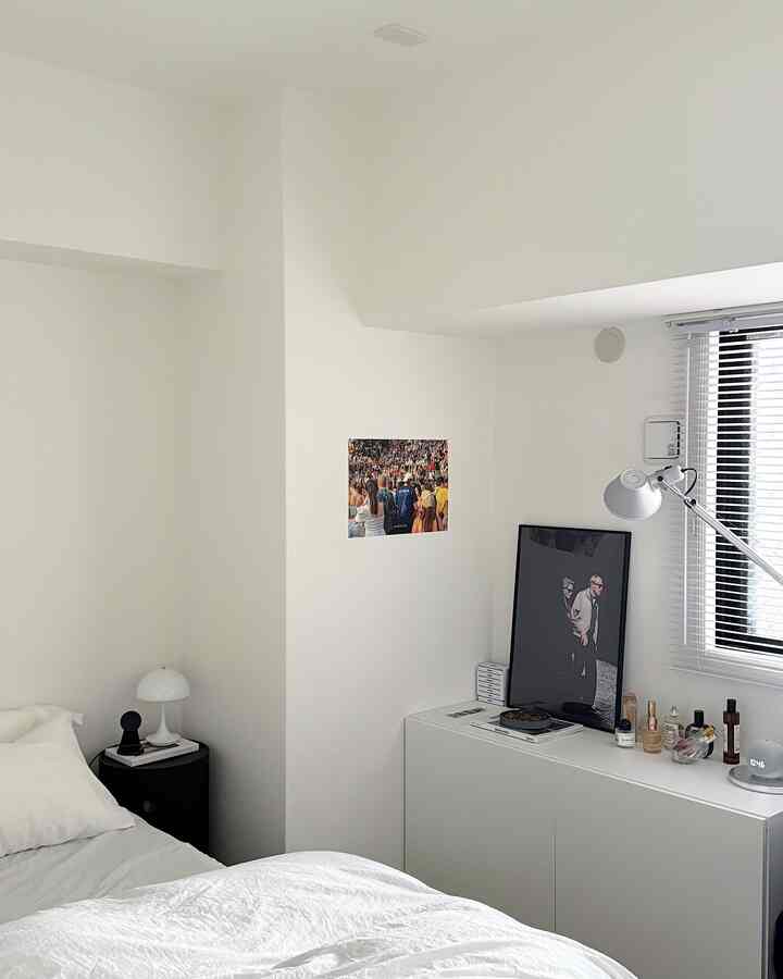 White-toned bedroom featuring a white bed and a white cabinet, creating a simple and clean space