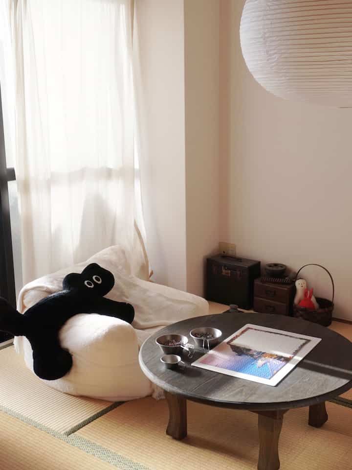 ナチュラルなベージュ色調の和室4.5畳、白のアームチェアと丸い木製テーブルが配置された居心地の良いインテリア