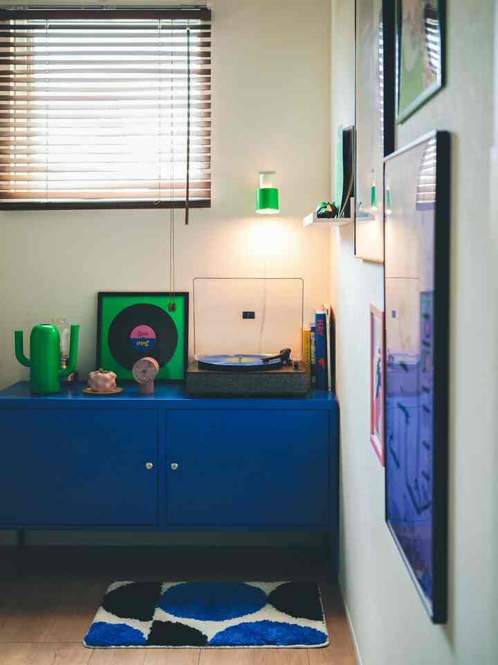 ブルーとグリーンの色調の部屋、レトロスタイルのブルーのチェストとヴィンテージ小物が配置された雰囲気のある空間