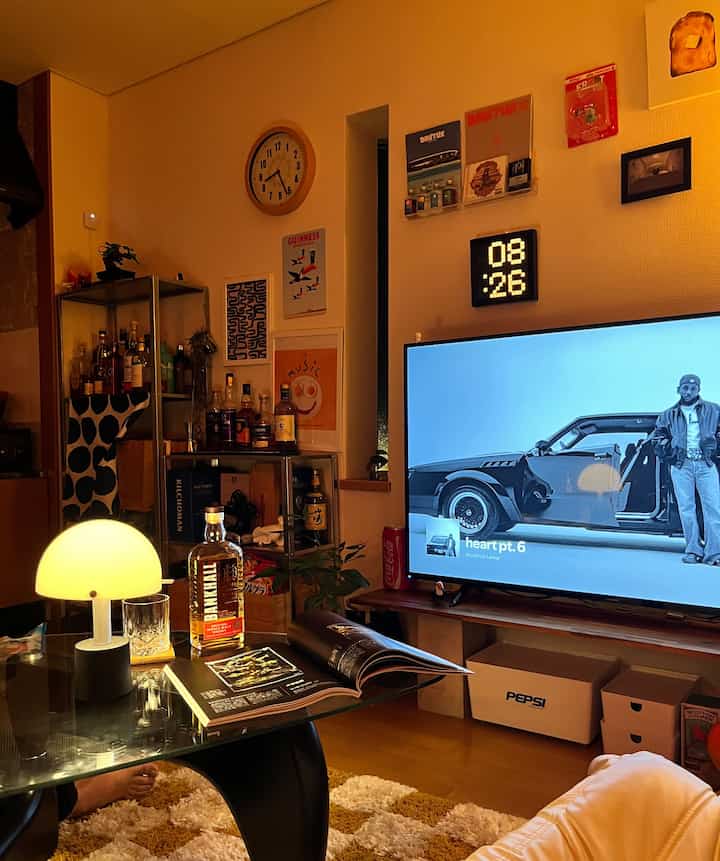 Warm yellow-lit living room featuring a mid-century modern home bar, sofa, and cozy decor elements