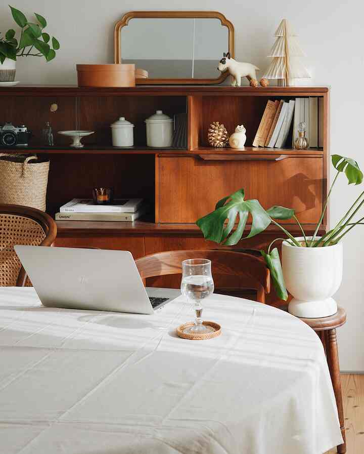 ナチュラルカラーと木目調のダイニング、Jentiqueのサイドボードと白いテーブルクロスの食卓が落ち着いた雰囲気を演出するインテリア。