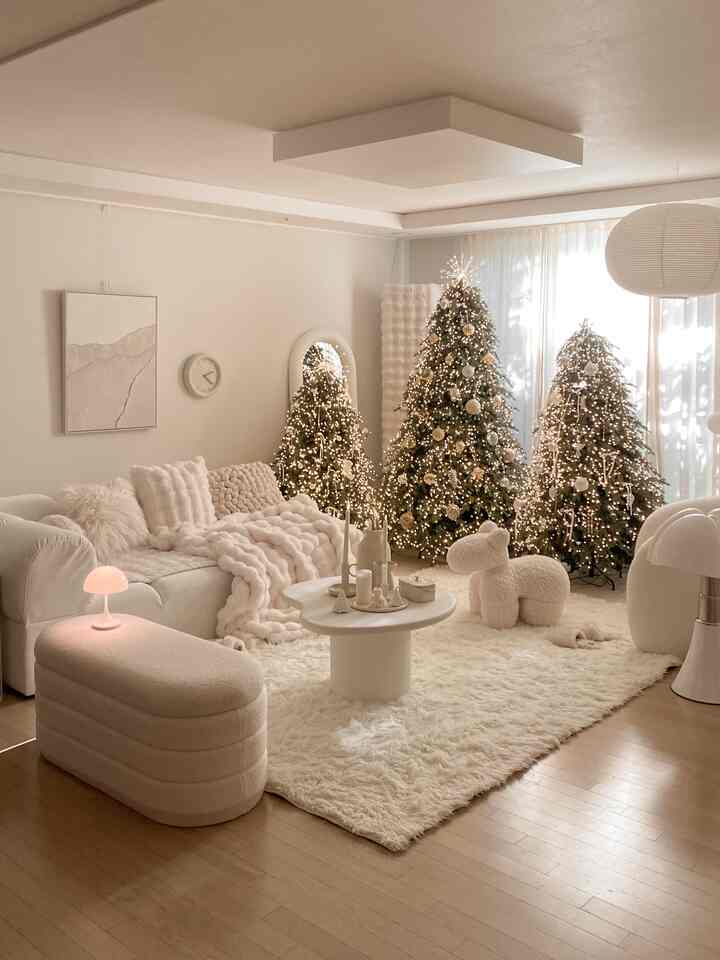白とベージュのトーンのリビング、クリスマスツリーと居心地の良いブランケットが配置された温かみのあるインテリア