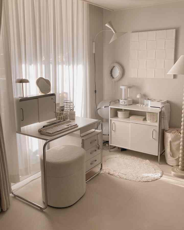 白とベージュのトーンのホームオフィス、スライド式収納と丸いスツールが配置された洗練されたモダンなインテリア