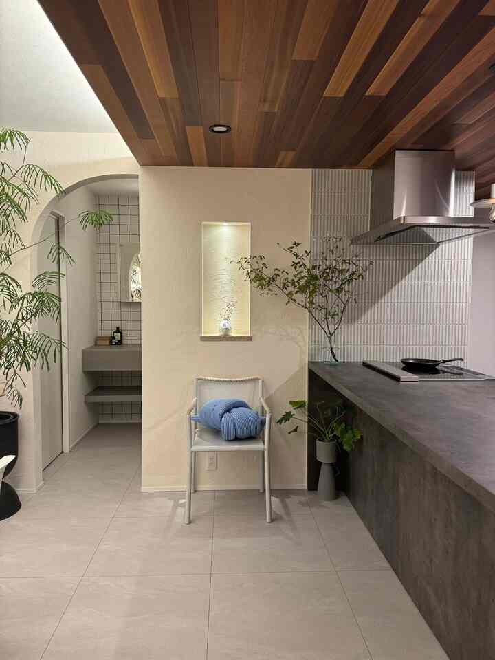Natural wood-tone ceiling entrance featuring a rope armchair and plants in a mid-century modern style space