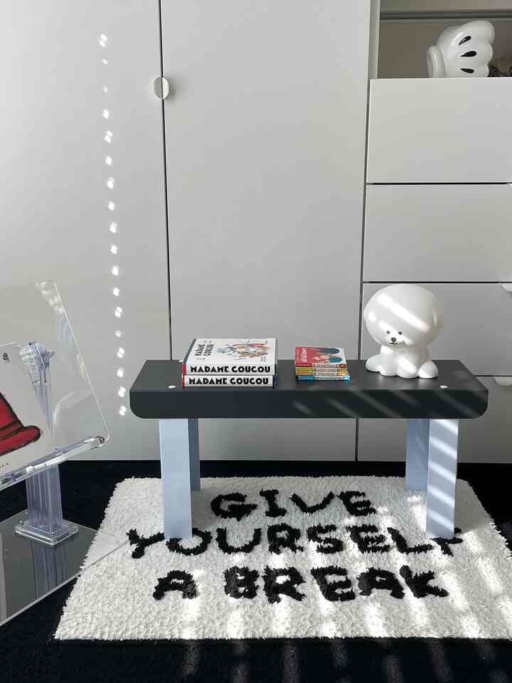 White and black toned entrance featuring a bench and a logo rug with a clean, modern feel