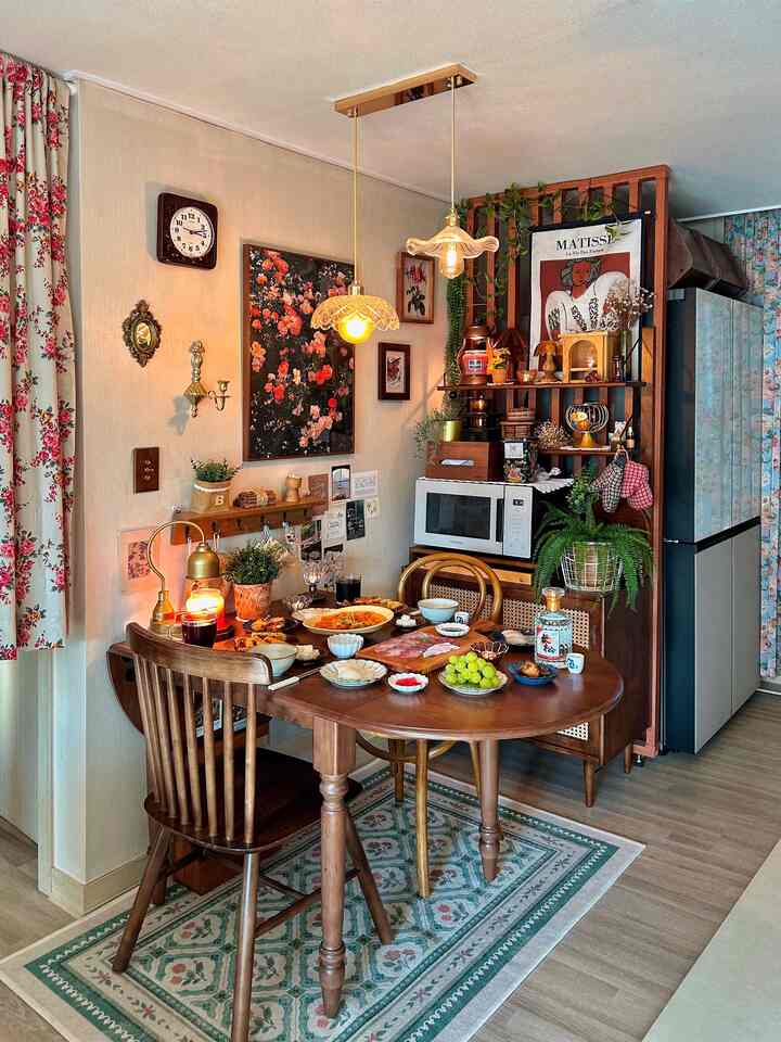 ベージュとウッドトーンが調和したヴィンテージスタイルのダイニングルーム、花柄のカーテンとヴィンテージ家具が暖かい雰囲気を作り出すインテリア