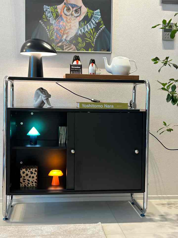 Modern minimal living room with chrome-frame black cabinet and white tone background creating a clean stylish atmosphere