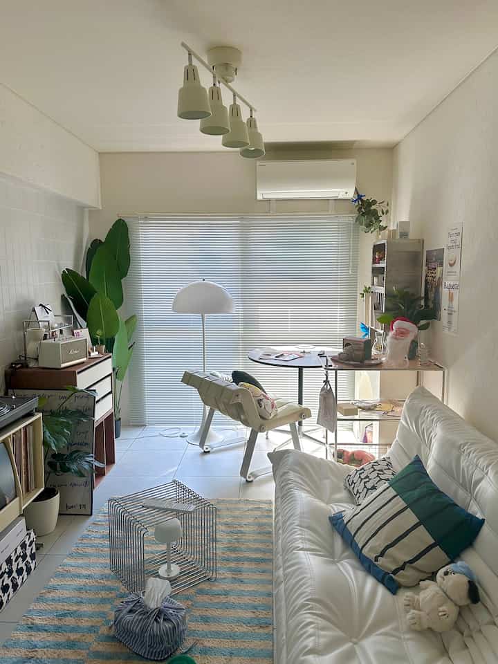 白を基調とした温かみのあるリビング、快適なソファとダイニングチェアが配置された印象的な空間